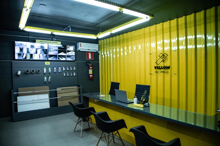 Recepção de uma unidade Yellow com monitores de câmeras de segurança